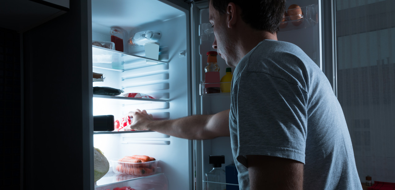 Visuel d'une personne en train de prendre des aliments dans un réfrigérateur
