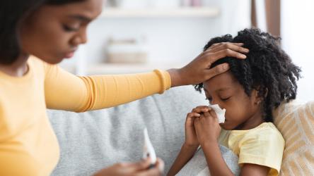Photo d'une maman en train de prendre la température de son enfant malade