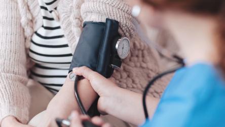 Photo d'un médecin en train de vérifier la pression artérielle d'une patiente