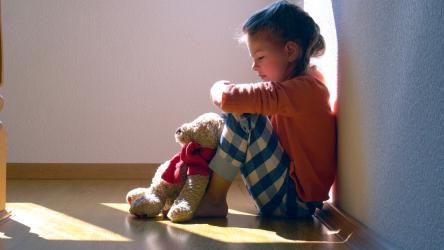 Photo d'une petite fille assise par terre et triste
