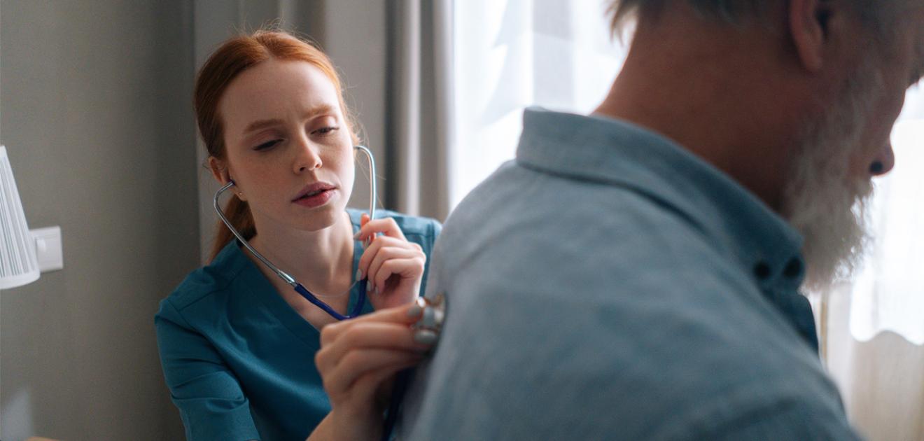 Un médecin ausculte un patient avec un stéthoscope