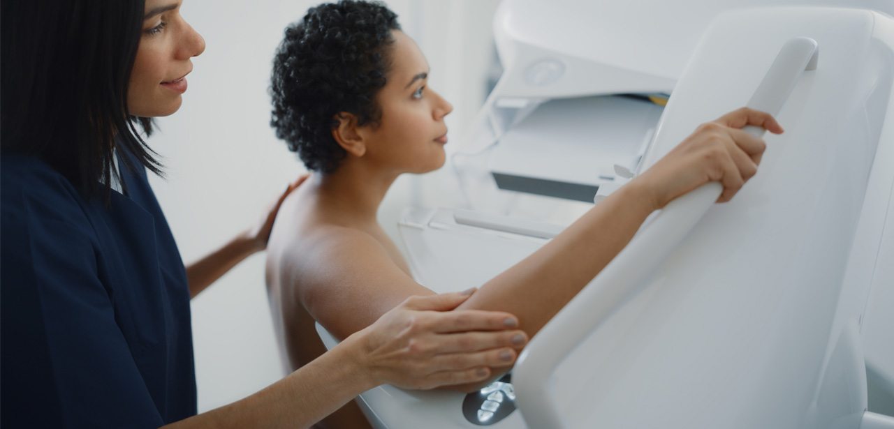 Une soignante aide une patiente pour sa mammographie