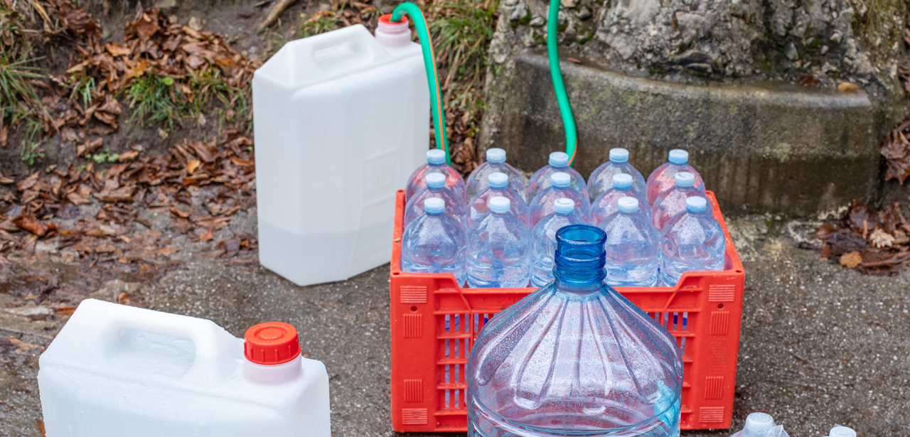 Photo de bouteilles d'eau et de contenants remplis par des tuyaux